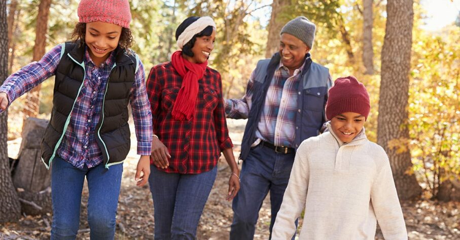 black family of 4 walking in the woods