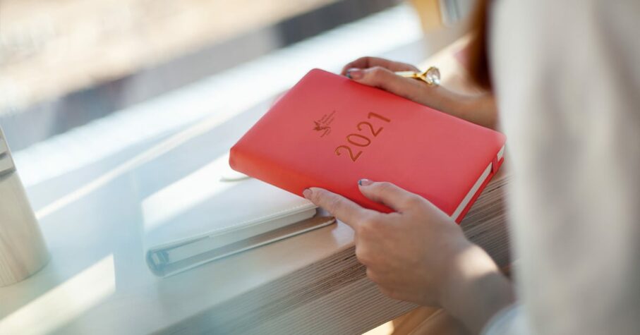 woman holding a red CPP 2021 planner