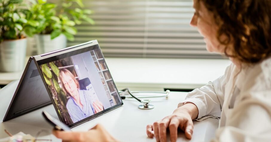 telemedicine concept elderly woman using laptop and taking her blood pressure