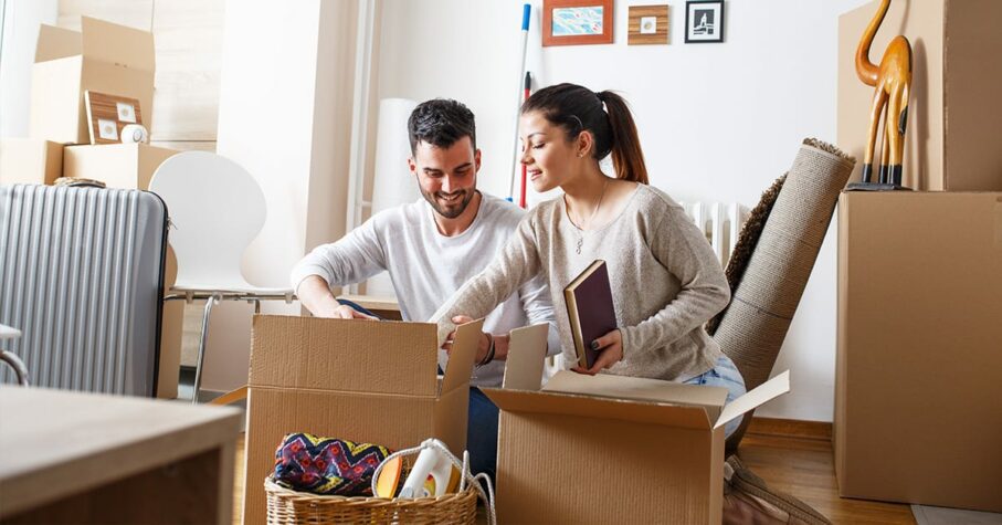 Young couple packing boxing to move new home