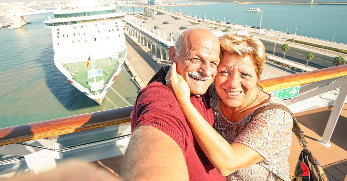 senior couple having a selfie in front of a cruise ship