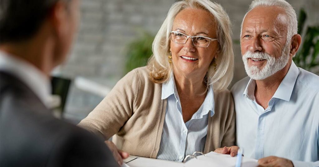 An elderly couple talking to their insurance advisor about estate planning