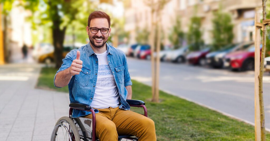 happy man on a wheelchair with his thumbs up